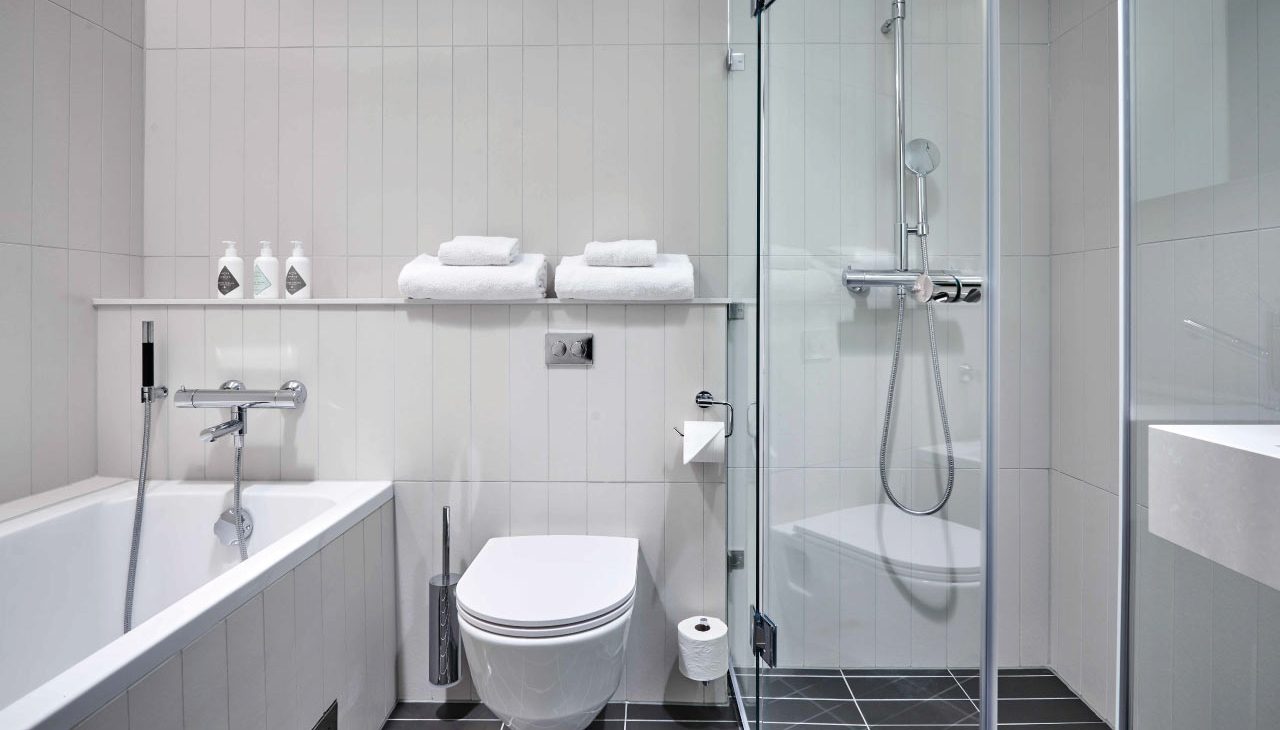 Helkaklat badrum med både dusch och bad på Nordic Light Hotel